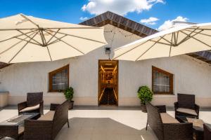 a patio with tables and chairs and umbrellas at Hotel Boutique18plus - Adults Only in Mamaia Sat/Năvodari