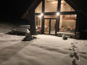 a house covered in snow at night with lights at Dom dwa światy in Międzybrodzie Bialskie +32 photos