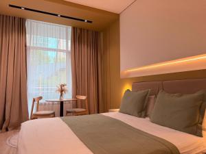 a bedroom with a bed and a table and a window at Sea Star Boutique Hotel in Almaty