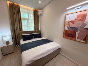 a bedroom with a bed and a painting on the wall at Sea Star Boutique Hotel in Almaty