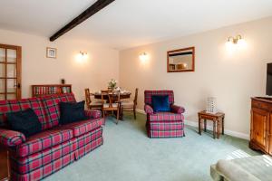 a living room with a couch and chairs and a table at Lupin Cottage in Wooler
