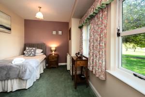 a bedroom with a bed and a window at Lupin Cottage in Wooler +32 photos