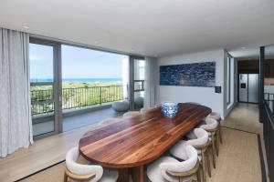 a dining room with a wooden table and chairs at Sonvanger Villa Struisbaai in Struisbaai