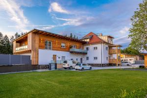 a house with two cars parked in a yard at Ferienbahnhof Fichtental Bahnhofs-Loft in Prackenbach