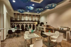 ein Restaurant mit Tischen und Stühlen und blauen Decken in der Unterkunft Hotel Silken Sirimiri in Bilbao