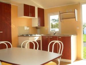 a kitchen with a table and chairs in a room at ZEcamping 4 étoiles pet friendly terrain multisports piscine couverte in Angles