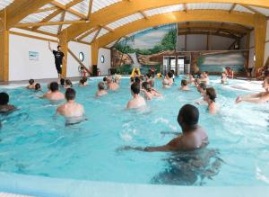 a group of people in a swimming pool at ZEcamping 4 étoiles pet friendly terrain multisports piscine couverte in Angles +58 photos