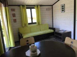 a living room with a couch and a table at ZEcamping 4 étoiles familial pet friendly animé piscine chauffée in Aramits