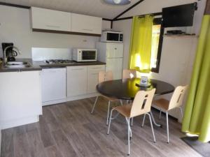 a kitchen with a table and chairs in a room at ZEcamping 4 étoiles familial pet friendly animé piscine chauffée in Aramits