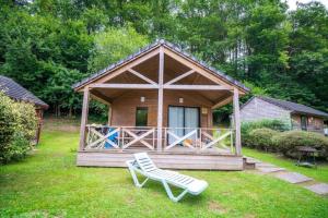a wooden cabin with a chair in the yard at ZEcamping 4 étoiles familial pet friendly animé piscine chauffée in Aramits