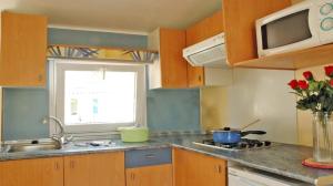 a kitchen with a sink and a stove and a window at ZEcamping 3 étoiles chiens acceptés piscine bar et restaurant in Mézel