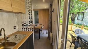 a kitchen with a sink and a table with chairs at ZEcamping 3 dog friendly piscine dans le parc régional du Verdon in Valensole