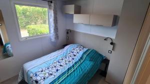 a small bedroom with a bed and a window at ZEcamping 3 dog friendly piscine dans le parc régional du Verdon in Valensole +32 photos
