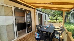 a patio with a table and chairs on a deck at ZEcamping 3 dog friendly piscine dans le parc régional du Verdon in Valensole