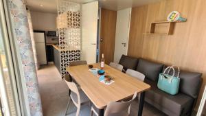 a dining room with a wooden table and chairs at ZEcamping 3 dog friendly piscine dans le parc régional du Verdon in Valensole