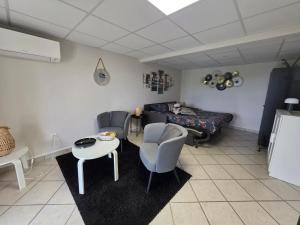 a living room with two chairs and a table at Châtel-guyon : Appart cosy avec place de parking et piscine près des thermes in Châtel-Guyon +7 photos