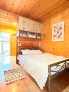 a bedroom with a bed and a wooden wall at Windy Hills in Noga