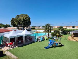 a large yard with a playground and a pool at Camping 3 étoiles - 1km de la plage - Piscine chauffée et Espace Fitness in Saint-Georges-de-Didonne