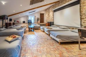 a room with a bunch of beds and a large screen at Mas Loisonville - 32 couchages in Grillon
