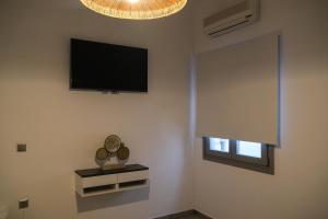a living room with a flat screen tv and a window at Antel apartment in Naousa