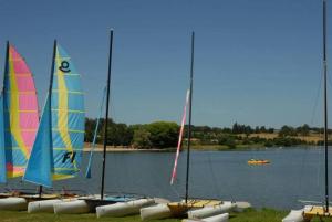a group of sailboats on a lake with a boat at ZEcamping 4 pet friendly piscine couverte et parcours Fitness in Pressignac