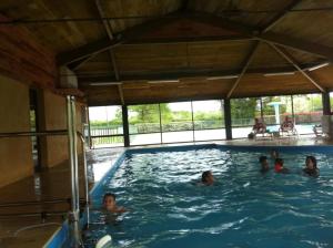 a group of people swimming in a swimming pool at ZEcamping 4 pet friendly piscine couverte et parcours Fitness in Pressignac