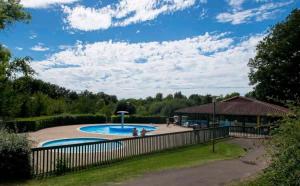 a swimming pool in a yard with a fence at ZEcamping 4 pet friendly piscine couverte et parcours Fitness in Pressignac +58 photos