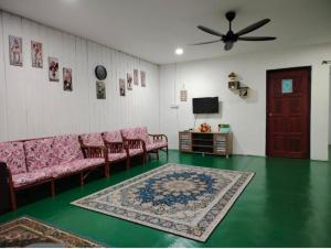 a living room with a couch and a tv at Homestay Bakti in Bandar  Pusat Jengka