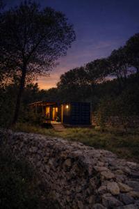 ein Haus mit einer Steinmauer davor in der Unterkunft Cabaña del Bosque in Canyelles