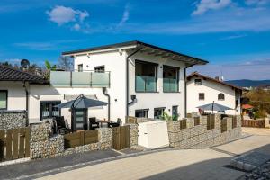 a white house with a fence in front of it at Riedbach-Lodge 2 in Viechtach