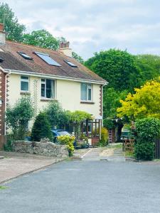 a house with a car parked in the driveway at Enstone Homestay in Sidmouth