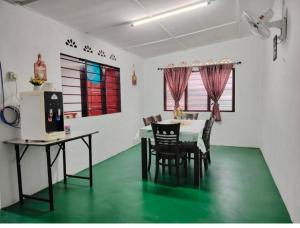 a dining room with a table and a green floor at Homestay Bakti in Bandar  Pusat Jengka
