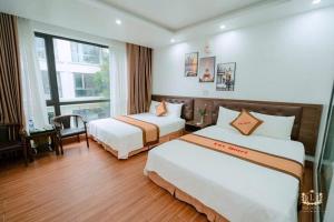 a hotel room with two beds and a window at Ks Luxhotel flc sầm sơn in Sầm Sơn