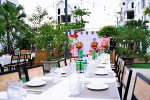a long table with white plates and glasses on it at Ks Luxhotel flc sầm sơn in Sầm Sơn