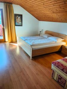 a bedroom with a bed and a wooden floor at Huberhof Abendsonne in Terento