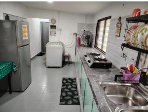 a kitchen with a sink and a refrigerator at Homestay Bakti in Bandar  Pusat Jengka +8 photos