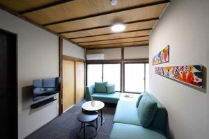 a living room with a couch and a tv at NOW Onomichi in Onomichi