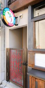 a building with a red door with a sign on it at NOW Onomichi in Onomichi