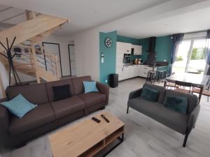 a living room with a couch and a table at Chez Audrey et Christophe in Saint-Pol-de-Léon
