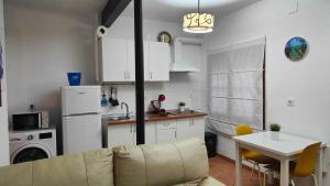 a living room with a couch and a table and a kitchen at El callejón del Santo in Ubrique