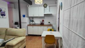 a kitchen and a living room with a couch and a table at El callejón del Santo in Ubrique +4 photos