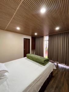 a bedroom with a large bed with a wooden ceiling at Zimba Cottage Retreat 2 in Kalimpong