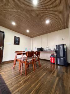 a dining room with a table and chairs and a kitchen at Zimba Cottage Retreat 2 in Kalimpong