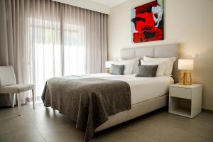 a bedroom with a bed and a large window at Giramar Apartamentos Turisticos in Lagos