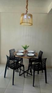 a dining room table with four chairs and a chandelier at Apto Beira Mar - Enseadas dos Corais in Cabo de Santo Agostinho +26 photos