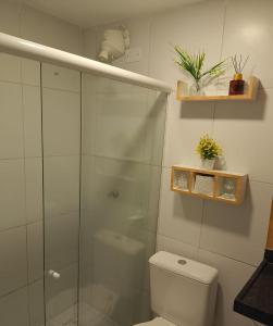 a bathroom with a toilet and a glass shower at Apto Beira Mar - Enseadas dos Corais in Cabo de Santo Agostinho