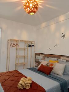 a bedroom with a bed with two pairs of shoes on it at Apto Beira Mar - Enseadas dos Corais in Cabo de Santo Agostinho