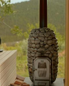 a stone fireplace sitting in front of a window at Quinta das Riquezas in Dornes