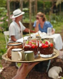a person holding a tray with desserts on it at Quinta das Riquezas in Dornes
