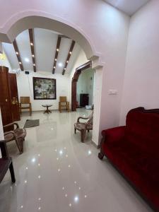 a living room with a red couch and chairs at Manasam Homes Near To IIM & NIT - kOZHIKODE in Kunnamangalam